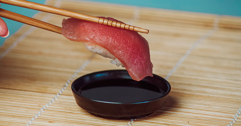 Na obrázku sa medzi dvoma paličkami nachádza sushi Nare